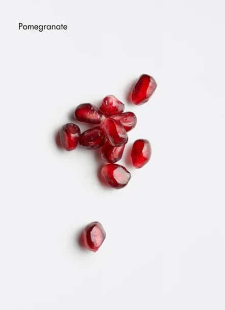 Fresh pomegranate seeds scattered on a white background, showcasing their vibrant red color.