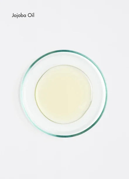 Jojoba oil in a glass dish, showcasing its light texture and natural purity.