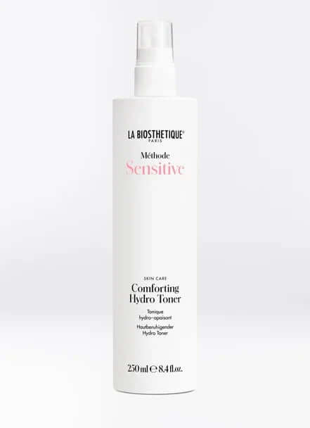 Comforting Hydro Toner for sensitive skin in a white spray bottle, vegan formula for soothing hydration.